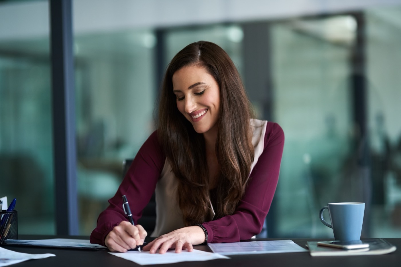 A payroll and HR professional making notes at an office desk
