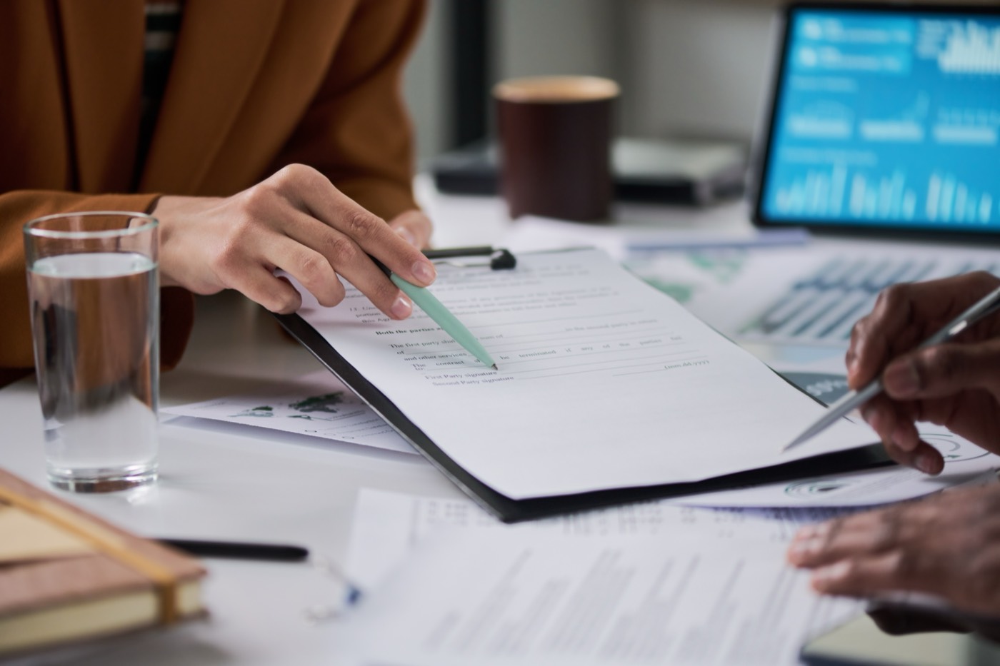 Colleagues reviewing payroll paperwork and figures at a desk