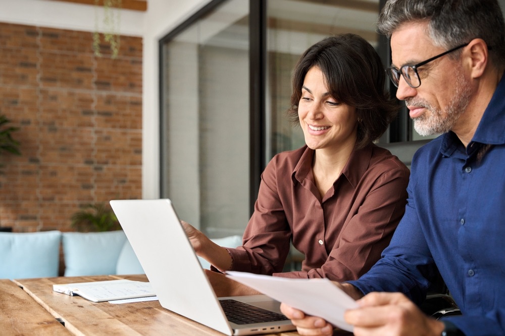 Payroll implementation consultant reviewing payroll documents with a business owner